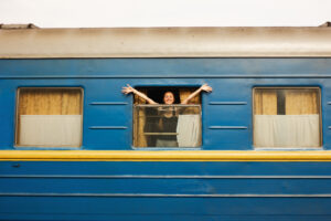 Woman on a train with arms stretched out